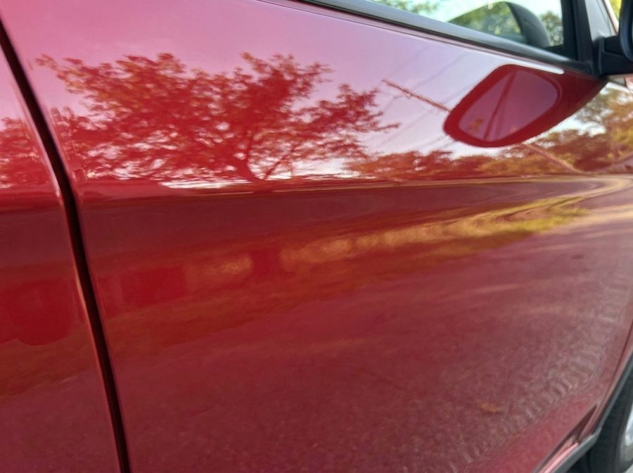 The same red car door smooth and dent-free after PDR